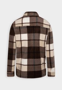 Camisa chaqueta de forro de cuadros en tonos marrón y crema con cuello. Presenta un gran patrón a cuadros, textura suave y un frente sin botones.