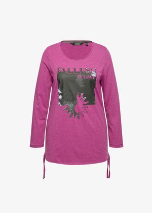 Langarmshirt aus leuchtend pinkem Baumwollstoff, mit einem schwarzen Grafikdruck und dem Text "Falling in Love", sowie seitlichen Bändern für eine verstellbare Passform.