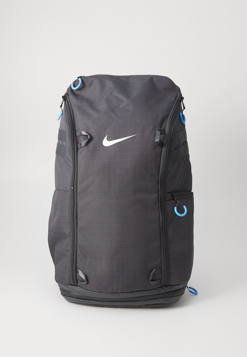 Schwarzer Nylon-Rucksack mit Karomuster, ausgestattet mit einem weißen Nike-Logo, blauen Reißverschlussakzenten und mehreren Seitentaschen zur Aufbewahrung.