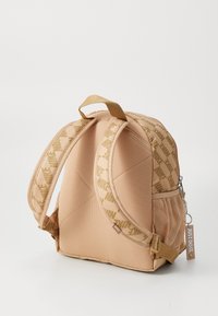 Beige ryggsekk med teksturert overflate, med mønstrede stropper, et topphåndtak og en sidelomme i mesh. Inkluderer en "Just Do It"-lapp.