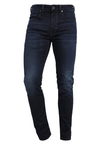 Mörkblå denimjeans med slim fit, med fem fickor, dragkedja och bälteslingor. Tyget har en mjuk textur med en lätt blekning.