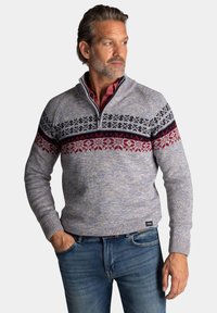 Gelaagde breipullover in lichtgrijs met een patroonband van rode, zwarte en witte sneeuwvlokken. Heeft een halflange ritskraag en geribbelde manchetten.