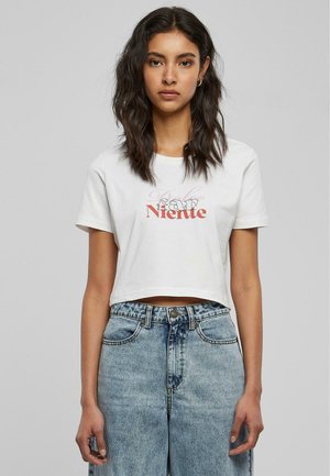 T-shirt blanc court avec un design de texte rouge et noir. Associé à un jean en denim bleu clair taille haute. Texture lisse, coupe décontractée.