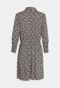 Květinové šaty s límečkem, dlouhými rukávy, úzkým pasem a černým pozadím pokrytým bílými a žlutými květinami.