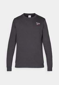 Sweat-shirt gris foncé en mélange de coton doux. Il présente un col rond, des manches longues et un petit logo Reebok rouge sur la poitrine.