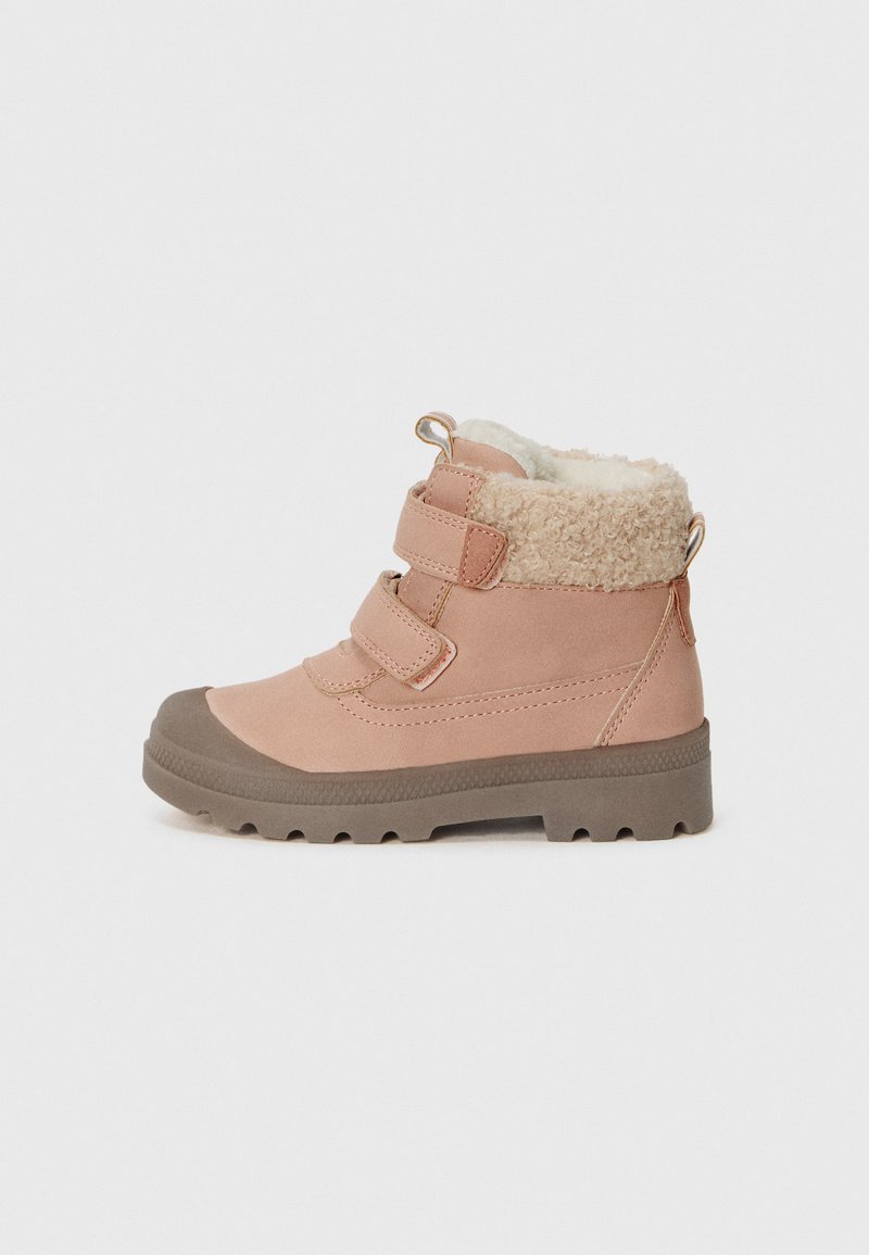 Bota de inverno rosa com duas tiras de velcro, forro de pelúcia bege e sola de borracha castanha grossa, apresentada de lado sobre fundo branco.