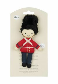 Měkká plyšová panenka v červené vojenské uniformě s černou kožešinovou čepicí, modrými džínovými kalhotami a přátelským výrazem ve tváři. Součástí je visačka s detaily.