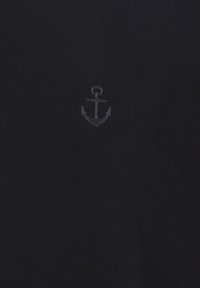 Mörkblå bomullst-shirt med en liten, broderad ankarsymbol i en ljusare nyans på vänstra bröstet. Mjuk textur, enkel design.