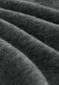 Soft dark gray fabric with visible texture and folds running diagonally across the frame, highlighting its plush and cozy surface.