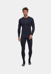 Black athletic long-sleeve shirt and leggings in smooth, stretchy fabric. Fitted design, subtle seam accents, and contrasting textured panel.