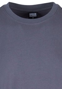 Szürke pamut póló kerek nyakkal és bordás textúrával. A belső nyakon található "URBAN CLASSICS" címke, M-es méret.