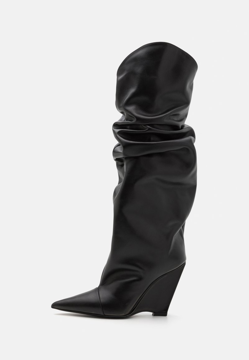 Svart knähög stövel i glatt, elastiskt material med spetsig tå och kilklack. Har en slapp design och glänsande yta.