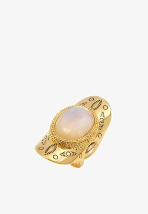 Bague en or avec un centre en pierre de lune ovale, entourée de détails texturés et de motifs complexes sur l'anneau. Fini lisse et poli.