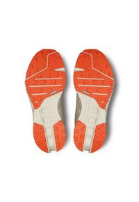 Atletische schoenen met een oranje rubberen zool met patroon en off-white accenten; voorzien van een gestructureerde grip en stabiliteitselementen.