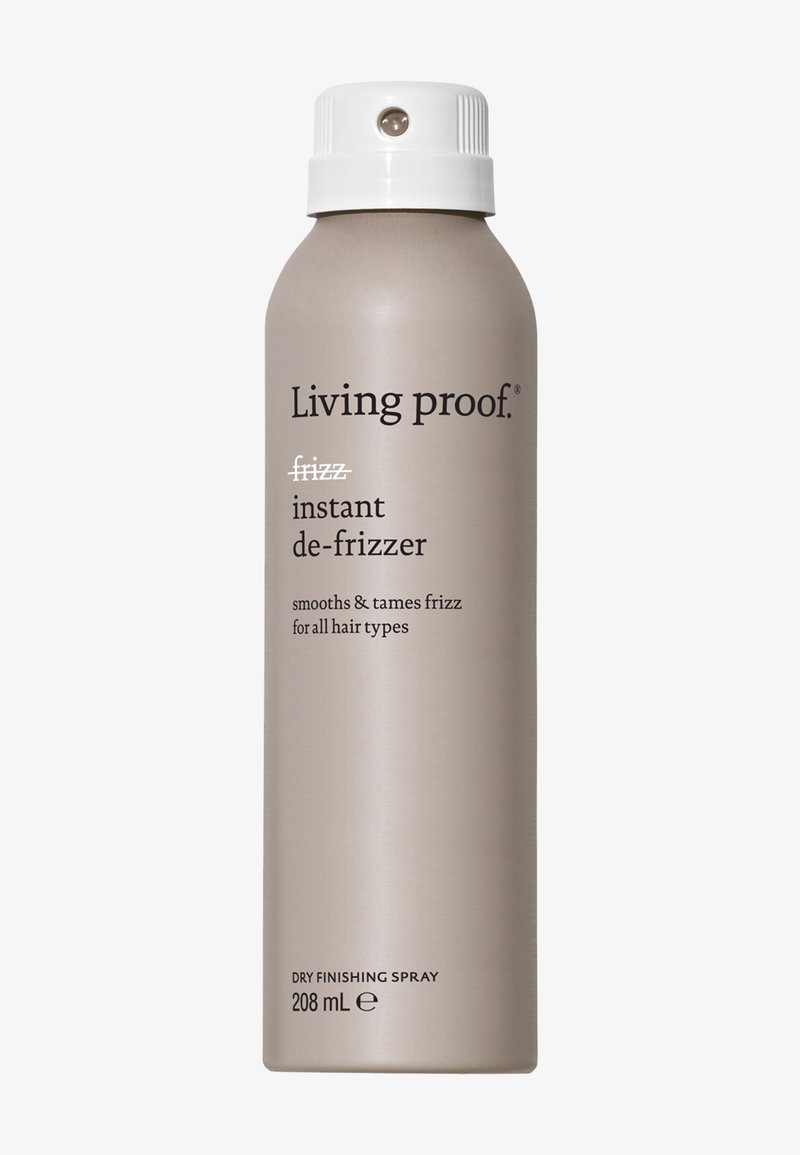 Grå aerosolbeholder med en hvit spraydyse, merket "Living proof frizz instant de-frizzer" i svart tekst, 208 mL størrelse, glatt metallisk overflate.