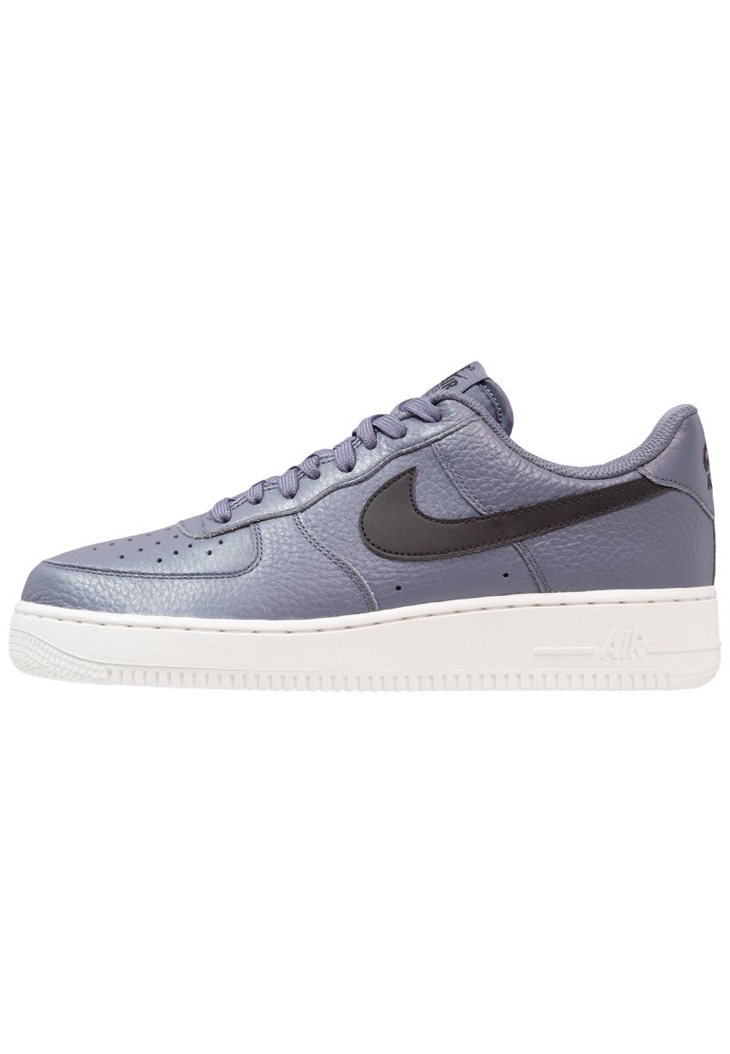 Sneakers Nike Air Force 1 w jasnofioletowej skórze, z czarnym swooshem, perforowanym noskiem i białą gumową podeszwą.