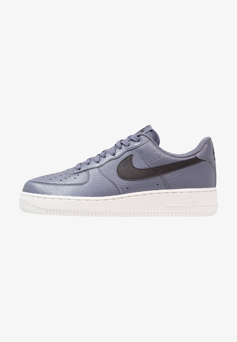 Sneakers Nike Air Force 1 w jasnofioletowej skórze, z czarnym swooshem, perforowanym noskiem i białą gumową podeszwą.