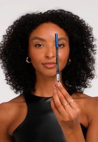 Black gel eyeliner pencil with a blue cap, held vertically. The model has textured curly hair and wears a sleeveless black top.