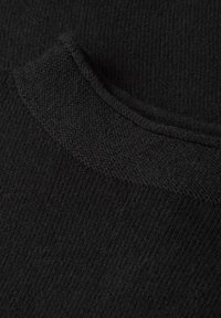 Primo piano di un maglione nero a maglia, con una texture liscia e dettagli a costine sul colletto e sulle maniche. Nessun motivo o accento distintivo.
