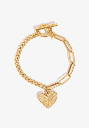 Gold bracelet with mixed chain links and a heart-shaped charm featuring a detailed wing design, secured by a toggle clasp.