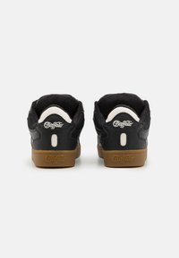 Zwarte sneakers met een gestructureerde leren bovenkant, witte accenten en een gumrubberen zool. Beschikt over een logo op de hiel en een ronde hiel lus.