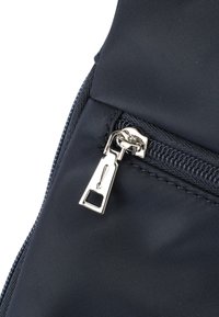Borsa in tessuto blu navale con dettaglio della cerniera argentata. Texture liscia, forma rettangolare, dotata di chiusura a zip funzionale con una maniglia prominente.