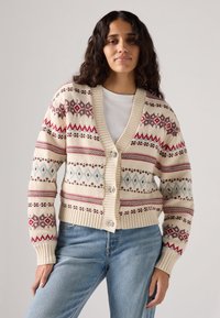 Cream cardigan featuring red, blue, and brown geometric patterns, ribbed cuffs and hem, and button closure with decorative buttons.