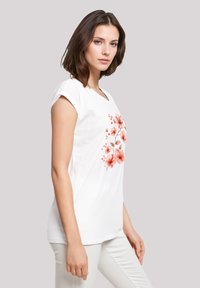 White short-sleeve T-shirt featuring a floral design in shades of pink and orange. Smooth cotton material, relaxed fit, rounded neckline.