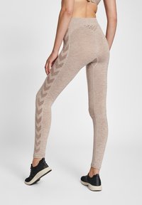 Beżowe legginsy o teksturowanym wykończeniu i wzorze w zygzak wzdłuż boku, z wysokim pasem i dopasowanym krojem.