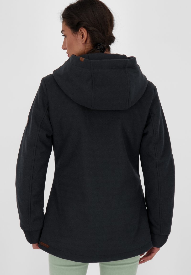 Ciemnoszara kurtka z kapturem o gładkiej teksturze, dopasowanym kroju i subtelnych detalach w szyciu. Posiada skórzany akcent na kapturze.