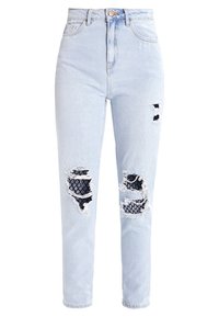Jeans de tiro alto de color azul claro con múltiples áreas rasgadas que revelan una tela negra con patrones debajo en los muslos frontales y las rodillas.