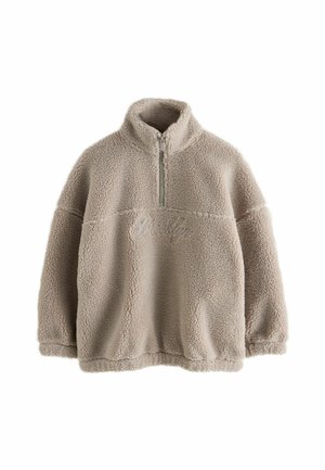 Pull beige en polaire sherpa avec demi-fermeture éclair devant et col haut, avec un texte brodé subtil sur la poitrine.