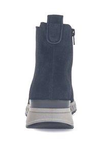 Botines de ante azul marino con acabado texturizado, cierre con cremallera trasera y suela gris contrastante con un pequeño tacón.