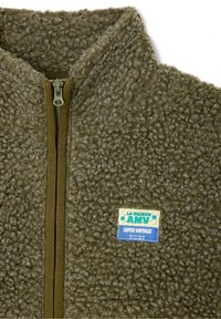 Olive roheline tekstuuriga fliisjakker, millel on eesnepp ja väike ristkülikukujuline patch, millel on rinnal kirjas "LA MAISON AMV SUPER VINTAGE".