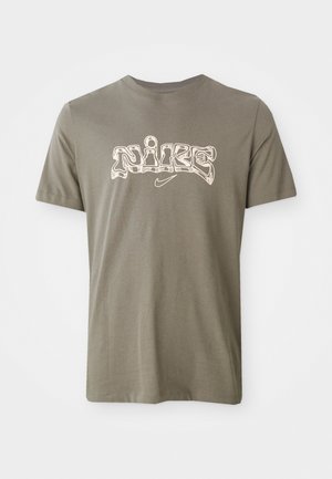 Olivengrøn bomulds t-shirt med et stiliseret hvidt "Nike" logo centreret på brystet. Kortærmet med rund halsudskæring.