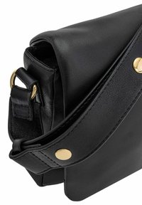 Czarna skórzana torba na ramię o teksturowanym wykończeniu, z złotymi detalami, klapą typu flip oraz regulowanym paskiem.