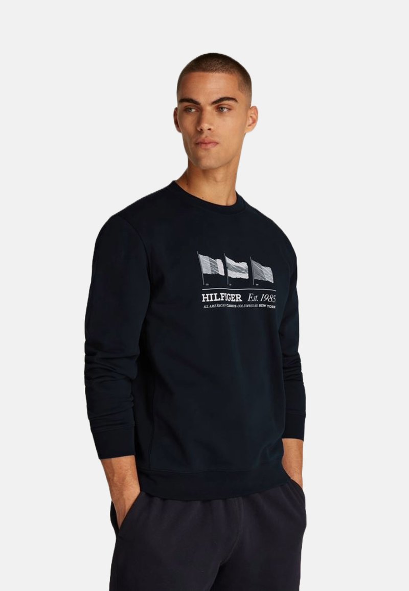 Sudadera de algodón azul marino con mangas largas, cuello redondo y un gráfico frontal de tres banderas con texto debajo.