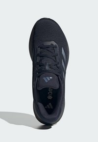 Zapatilla deportiva negra con parte superior de malla transpirable, cordones, suela acolchada y plantilla Ortholite. Presenta tres rayas en el lateral.