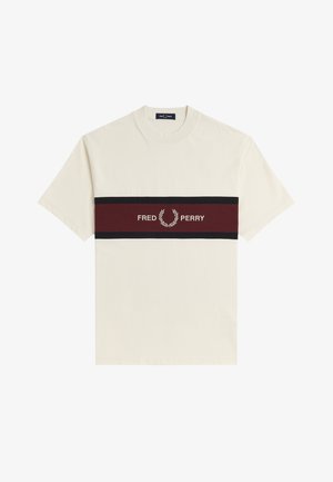 Camisa de manga corta color crema con una franja horizontal burdeos y negra que presenta el texto "Fred Perry" y el logo de la corona de laurel en el centro.