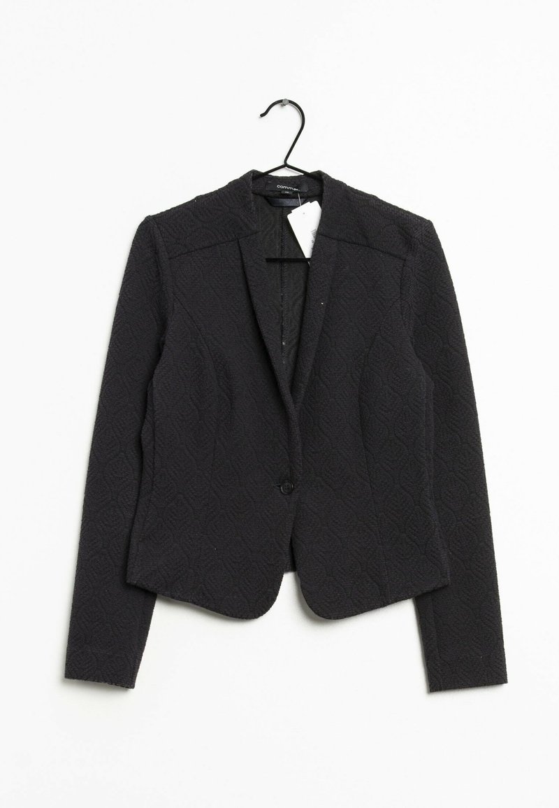 Blazer nero con texture, caratterizzato da un design aderente, colletto a punta, chiusura con un bottone e spalle strutturate. Appeso a un gancio.