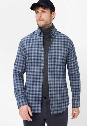 Blau-schwarz kariertes Flanellhemd mit langen Ärmeln, Knopfverschluss und weicher Textur, über einem dunklen Rollkragenpullover getragen.