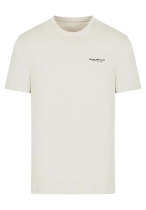 Kremowa koszulka Armani Exchange z krótkim rękawem, z małym czarnym logo na górnej lewej części klatki piersiowej.