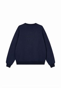 Felpa blu navy con scollo a girocollo e polsini a costine. Presenta un testo embossato sul retro: "IMPEGNATO A CREARE LA MIA MAGIA." Texture morbida.