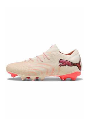 Hellbeiger Fußballschuh mit pinken Schnürsenkeln, roten Stollen an der Sohle und einem roten Puma-Logo an der Seite.
