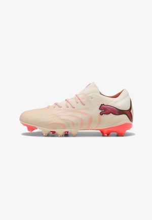 Hellbeiger Fußballschuh mit pinken Schnürsenkeln, roten Stollen an der Sohle und einem roten Puma-Logo an der Seite.