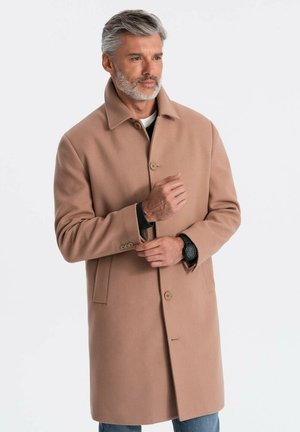 Manteau en laine brun clair avec un col haut, design à un seul boutonnage et fermetures à boutons ; texture douce et coupe droite, porté sur un haut noir.