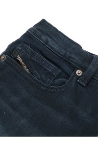 Jeans en denim bleu foncé avec une fermeture à boutons, une poche arrière avec un label logo et une texture subtile dans le tissu.
