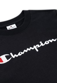 Felpa nera in cotone, con logo "Champion" ricamato bianco e accentato di rosso. Collo rotondo e texture morbida.