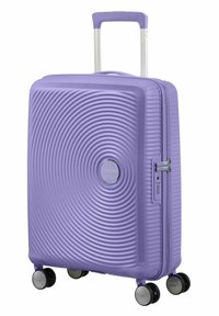 Valigia rigida di colore lavanda con texture circolare concentrica. Caratterizzata da un manico telescopico, quattro ruote e meccanismo di chiusura a combinazione.