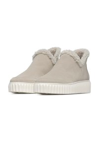 Beige suède enkelboots met een pluizige, gestructureerde bontkraag en een rubberen, geribbelde zool voor grip en ondersteuning.